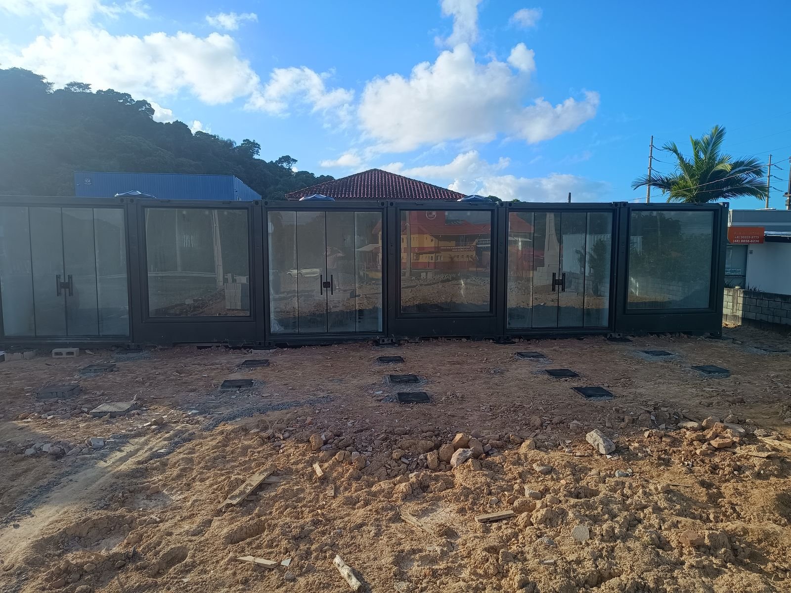 Terreno com containers posicionados e solo ainda em preparo