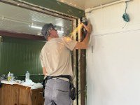 Profissional instalando acabamento na parede durante a obra